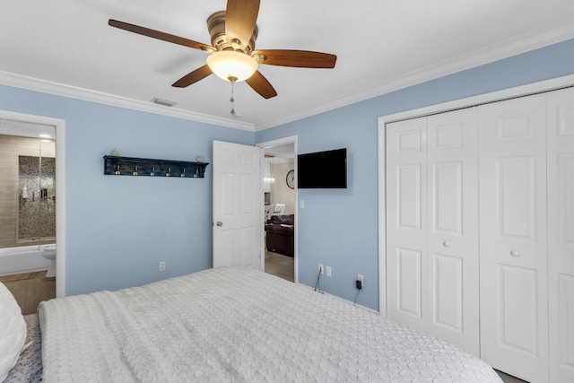 bedroom with ceiling fan, ensuite bath, ornamental molding, and a closet