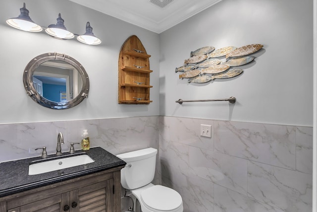 bathroom featuring vanity, crown molding, tile walls, and toilet