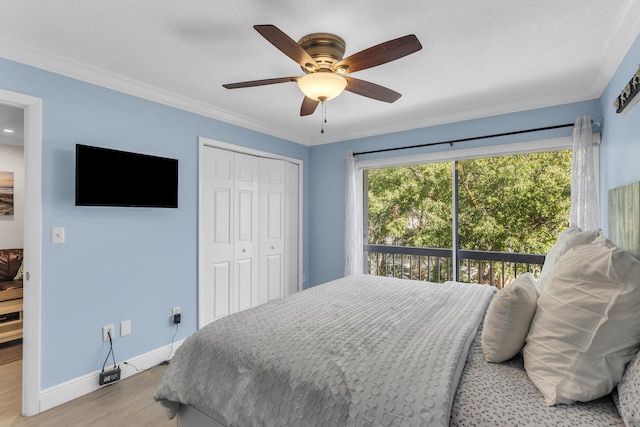 bedroom with crown molding, a textured ceiling, light wood-type flooring, a closet, and ceiling fan