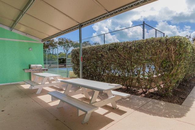 view of patio / terrace featuring grilling area and tennis court