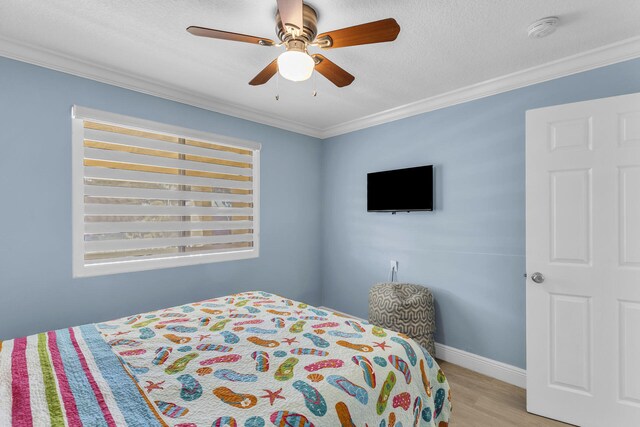 bedroom featuring ornamental molding, ceiling fan, a textured ceiling, and light hardwood / wood-style flooring