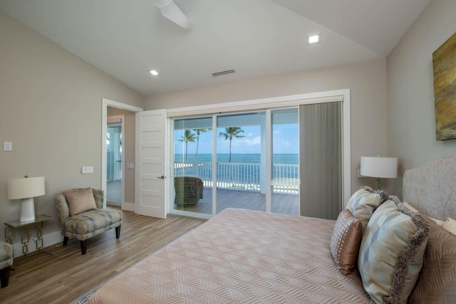 bedroom with access to outside, a water view, visible vents, vaulted ceiling, and light wood-type flooring