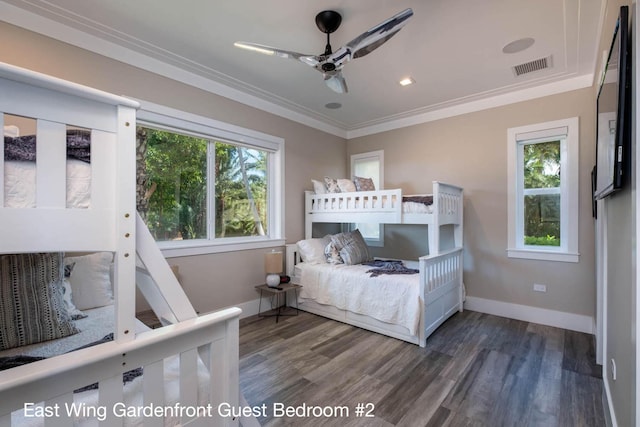 bedroom featuring crown molding, dark hardwood / wood-style flooring, and multiple windows