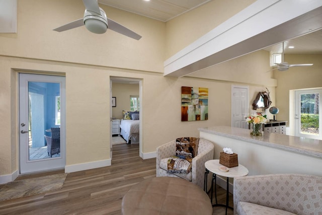 living area featuring ceiling fan, wood-type flooring, and high vaulted ceiling