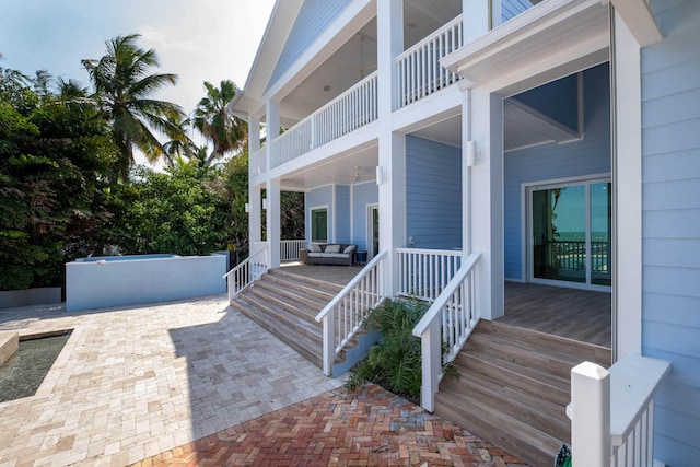 entrance to property with outdoor lounge area, a patio, a balcony, and a swimming pool