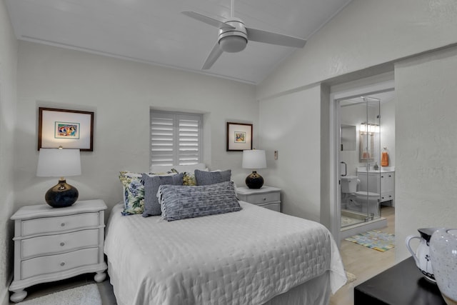 bedroom with ceiling fan, vaulted ceiling, wood finished floors, and ensuite bathroom