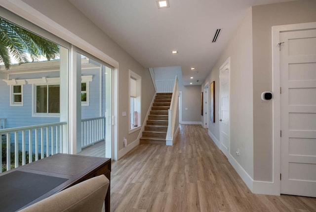 hall featuring light wood-style floors, recessed lighting, stairway, and baseboards