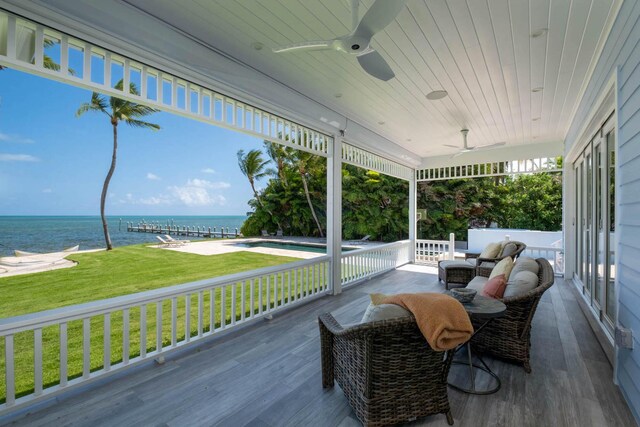 deck featuring a water view, a yard, and ceiling fan