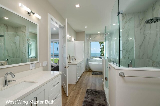 bathroom featuring wood-type flooring, shower with separate bathtub, and vanity