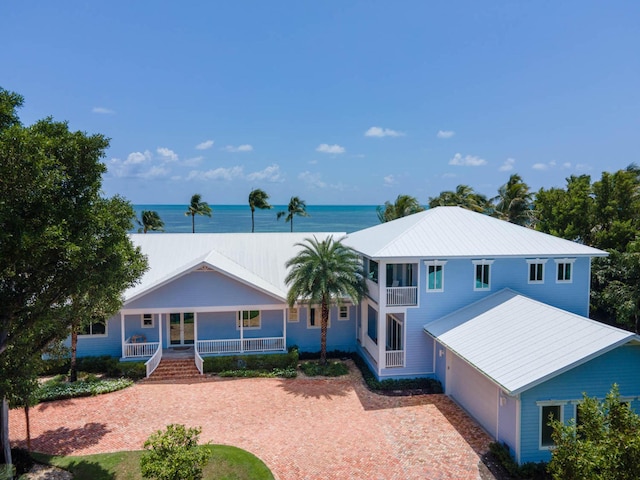 view of front of house featuring decorative driveway, covered porch, and a water view