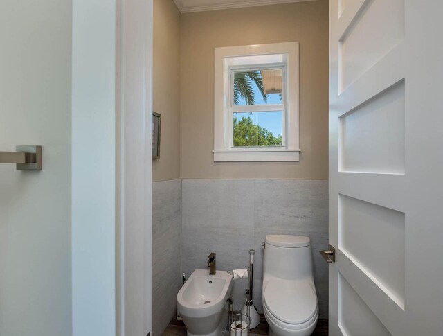 bathroom featuring a bidet, tile walls, and toilet