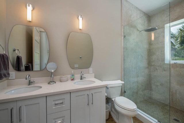 bathroom featuring vanity, tiled shower, and toilet