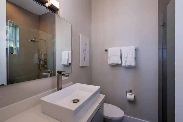 bathroom featuring vanity, tiled shower, and toilet