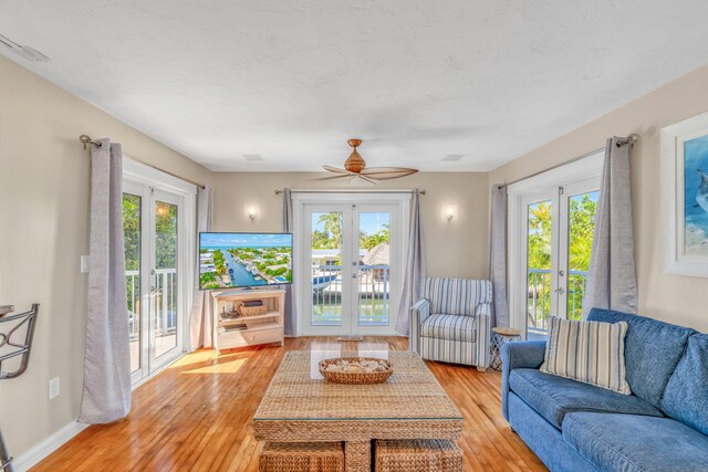 living room featuring plenty of natural light, french doors, and light wood-style floors