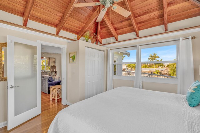 bedroom with lofted ceiling with beams, french doors, wooden ceiling, light wood finished floors, and baseboards