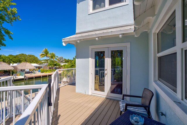 wooden deck with french doors and a water view