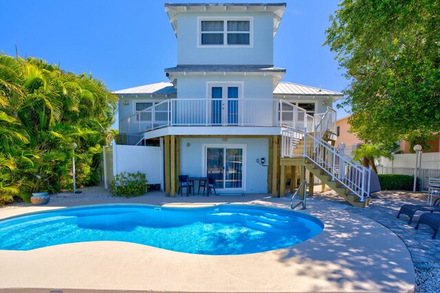 back of property featuring a fenced in pool, a patio, stairs, and fence