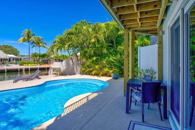 outdoor pool with a patio and fence