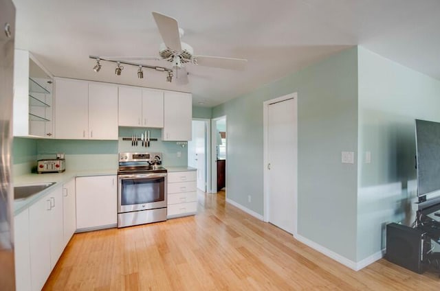 kitchen featuring light wood finished floors, white cabinets, stainless steel electric range oven, and light countertops