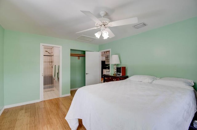 bedroom with connected bathroom, a closet, a ceiling fan, baseboards, and wood finished floors