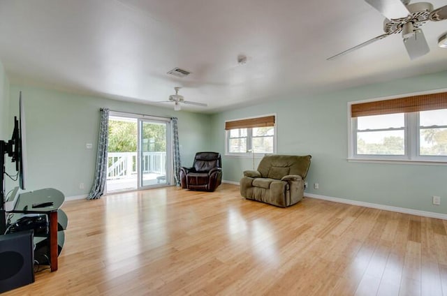 living area featuring ceiling fan, baseboards, wood finished floors, and visible vents