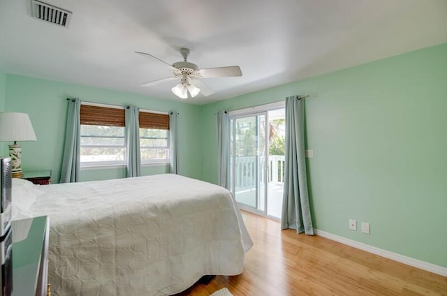 bedroom featuring access to outside, a ceiling fan, visible vents, light wood-style flooring, and baseboards
