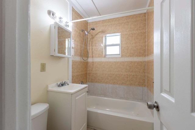 full bathroom featuring tiled shower / bath, vanity, and toilet