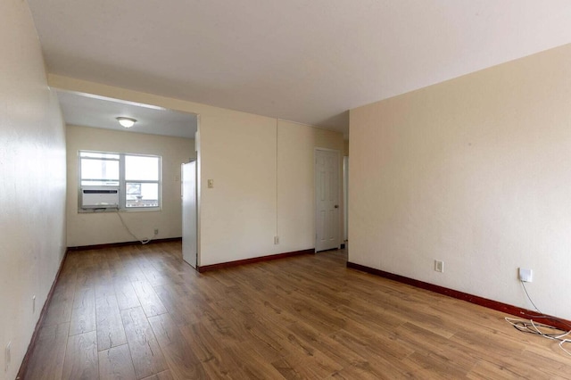 empty room featuring cooling unit and hardwood / wood-style floors