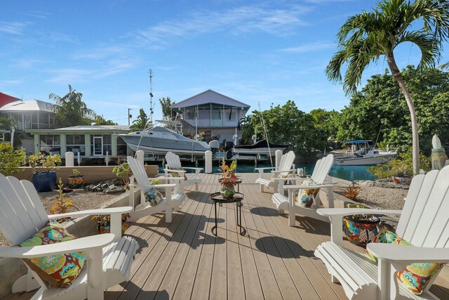 wooden terrace featuring a water view and a boat dock