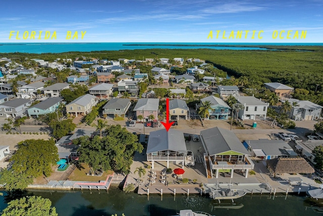 back of property with a deck with water view, a sunroom, and a patio