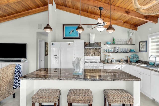 kitchen featuring pendant lighting, white appliances, white cabinetry, dark stone countertops, and a kitchen island