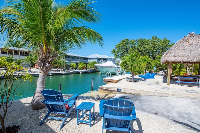 view of patio with a gazebo, a boat dock, and a water view