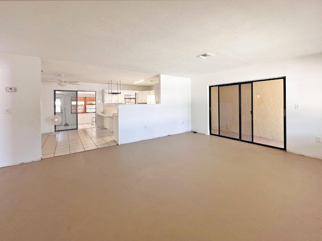 unfurnished living room featuring concrete flooring and ceiling fan