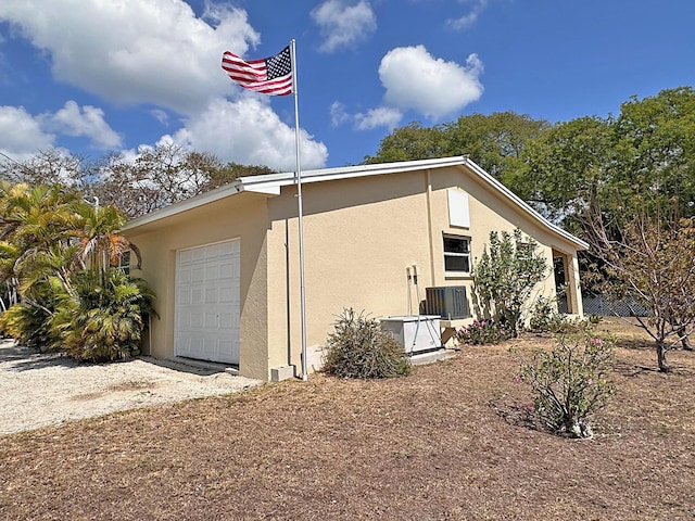 view of side of property with stucco siding and a garage