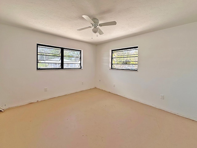 unfurnished room with ceiling fan and concrete flooring