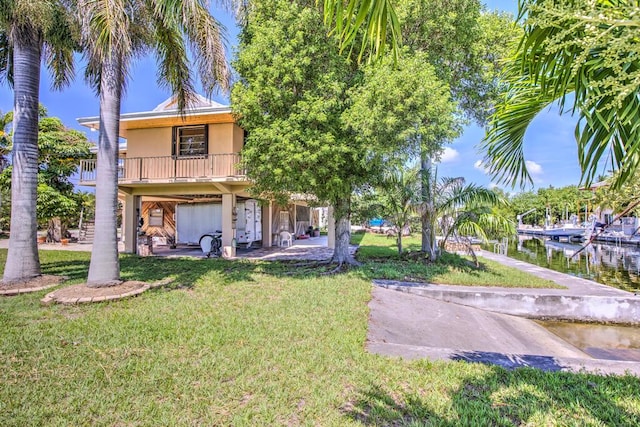 22865 Redfish Ln, Cudjoe, FL 33042 - back of property featuring stucco siding, a lawn, a water view, and a balcony