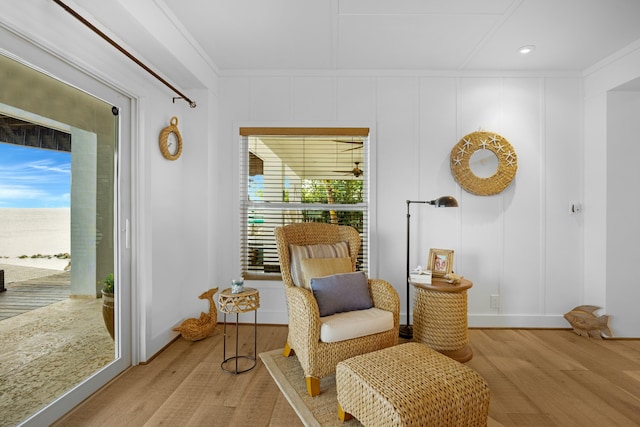 sitting room featuring ornamental molding and light hardwood / wood-style floors