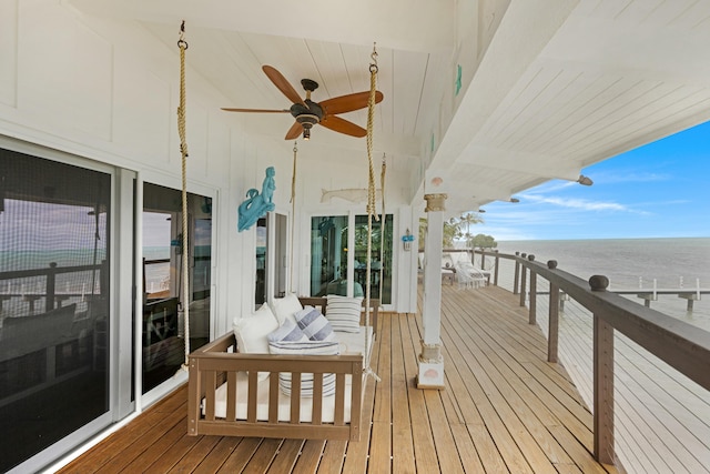 wooden terrace featuring ceiling fan and a water view