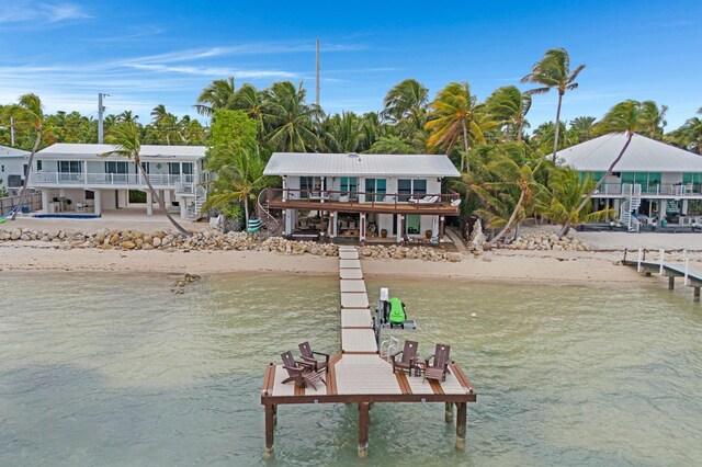 dock area featuring a beach view and a water view