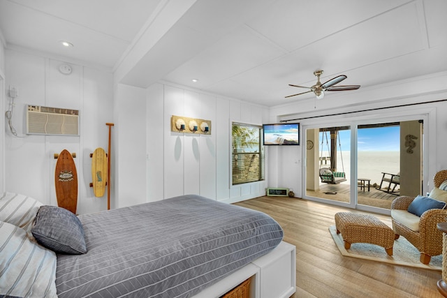 bedroom featuring ceiling fan, an AC wall unit, light hardwood / wood-style flooring, and access to outside