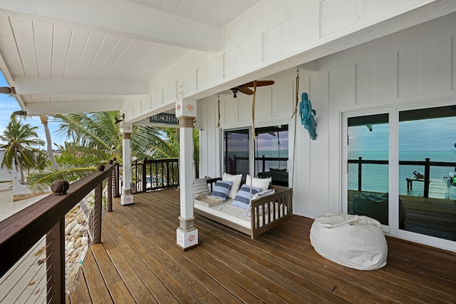 deck featuring a water view, ceiling fan, and outdoor lounge area