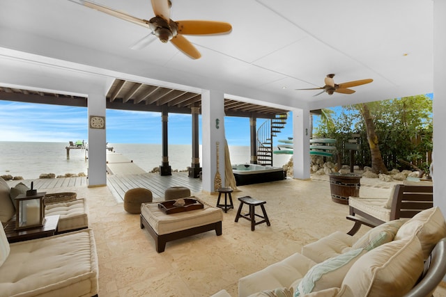 view of patio / terrace with a water view, ceiling fan, and an outdoor living space