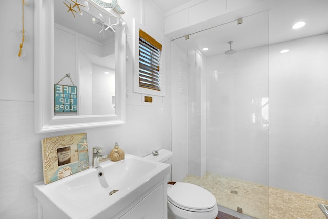 bathroom featuring vanity, toilet, and a tile shower