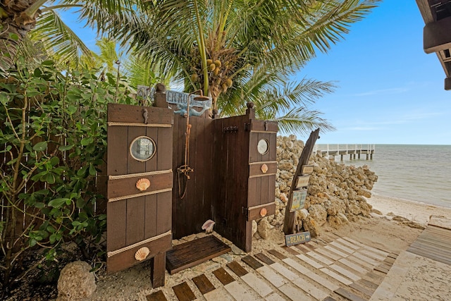 exterior space with a water view and a beach view