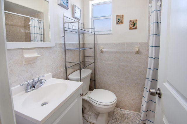 bathroom with vanity, toilet, a shower with shower curtain, and tile walls