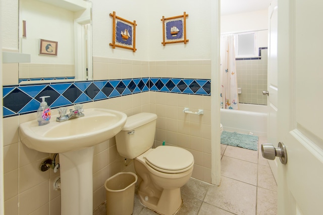 bathroom featuring shower / bath combination with curtain, tile patterned floors, toilet, and tile walls