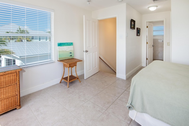 bedroom with multiple windows, baseboard heating, and light tile patterned flooring