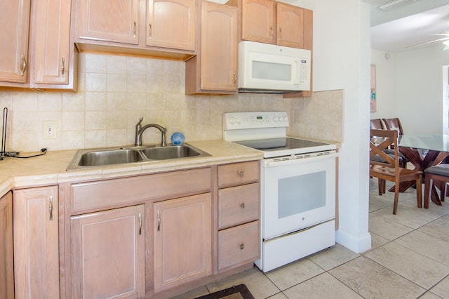 kitchen with light tile patterned flooring, light brown cabinetry, tasteful backsplash, sink, and white appliances