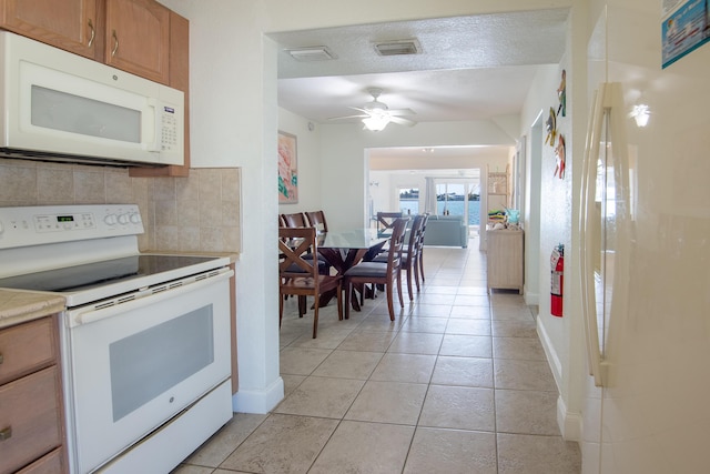 kitchen featuring light tile patterned floors, white appliances, decorative backsplash, and ceiling fan