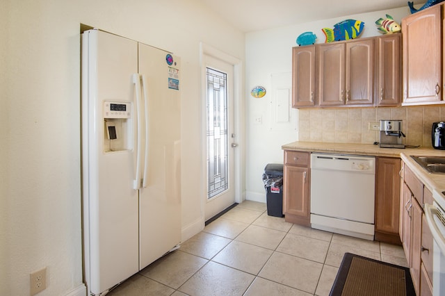 kitchen featuring tasteful backsplash, light tile patterned floors, and white appliances